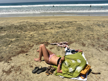 Man lying down on sand at beach