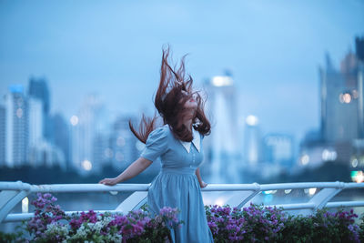 Rear view of woman with arms raised against sky