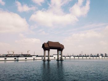 Pier on sea against cloudy sky