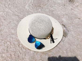 High angle view of sunglasses and hat at beach