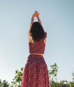 Rear view of woman standing against clear sky