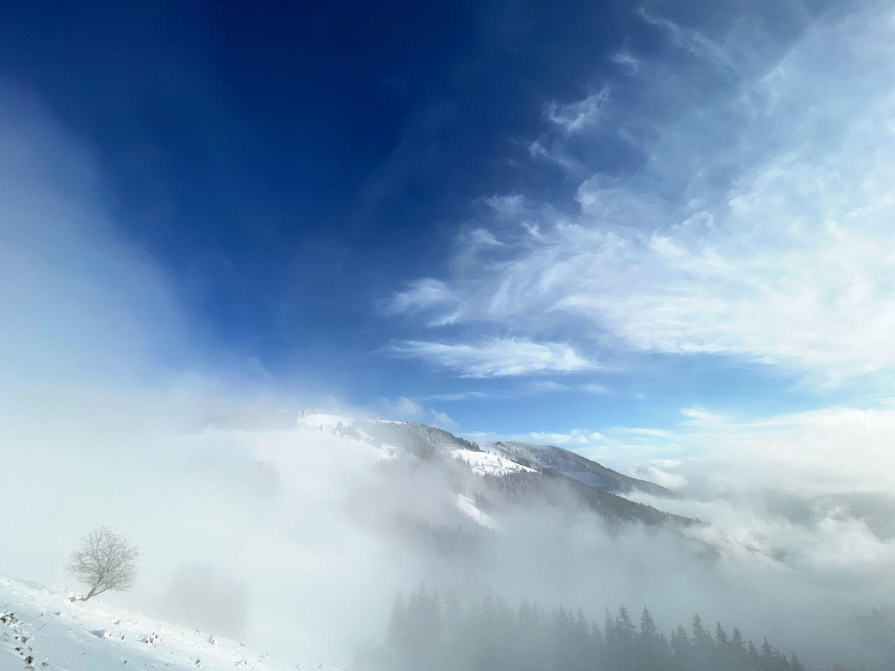 LOW ANGLE VIEW OF CLOUDS OVER MOUNTAINS