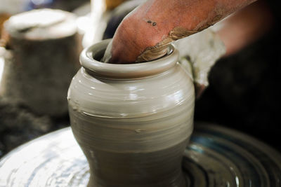 Midsection of man working on pottery wheel