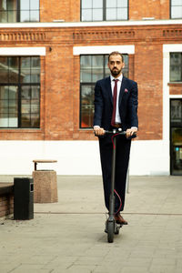 Full length of young man standing against building