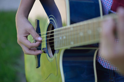 Midsection of man playing guitar