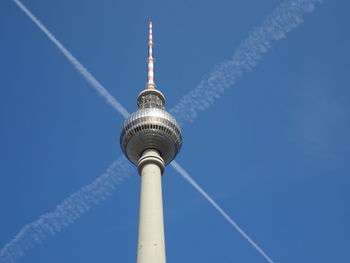 Low angle view of communications tower against blue sky