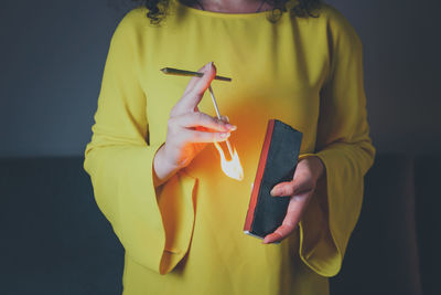 Midsection of woman holding paper