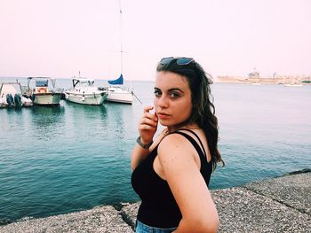 Portrait of young woman in sea against sky