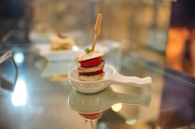 Close-up of appetizer in spoon on glass table