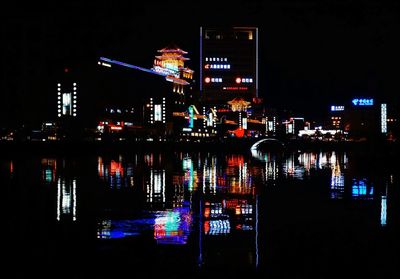 Illuminated city against sky at night