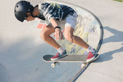 Empowered skater girl doing the drop in at the bowl of the skate park in berlin