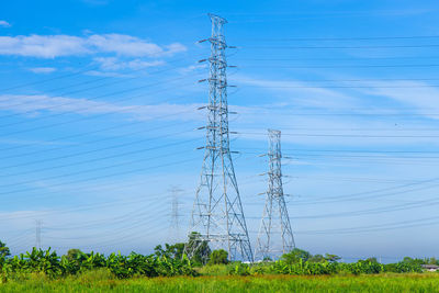 Low angle view of electricity pylons against sky