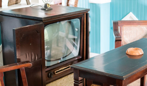 Close-up of table with television set at home