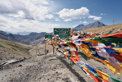 Multi colored flags on mountain against sky