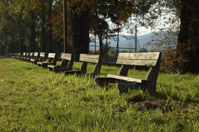 Empty bench on field in park