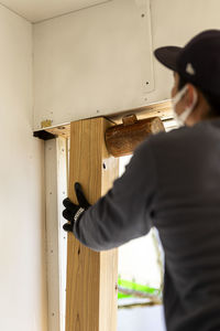 Side view of man looking through window