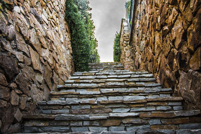 Staircase amidst stone wall of building