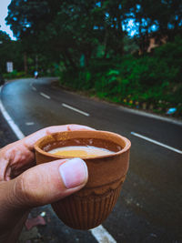 Close-up of hand holding ice cream cone on street