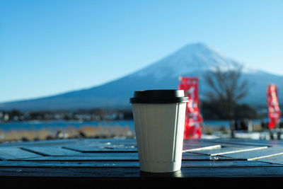 Close-up of drink on table against mountain range