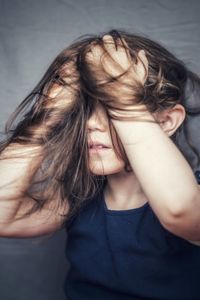Close-up of girl holding her messy brown hair