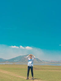 Full length of man standing on field against sky