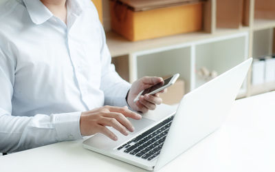 Midsection of woman using mobile phone