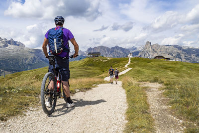 Rear view of man riding bicycle on field