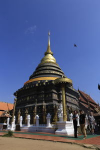 People at temple against clear sky