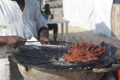 Man working on barbecue grill at market