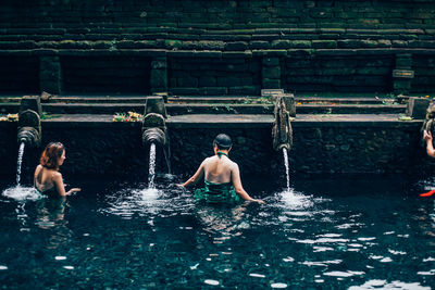 Full length of shirtless man swimming in pool