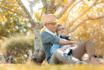 Rear view of father and son on tree