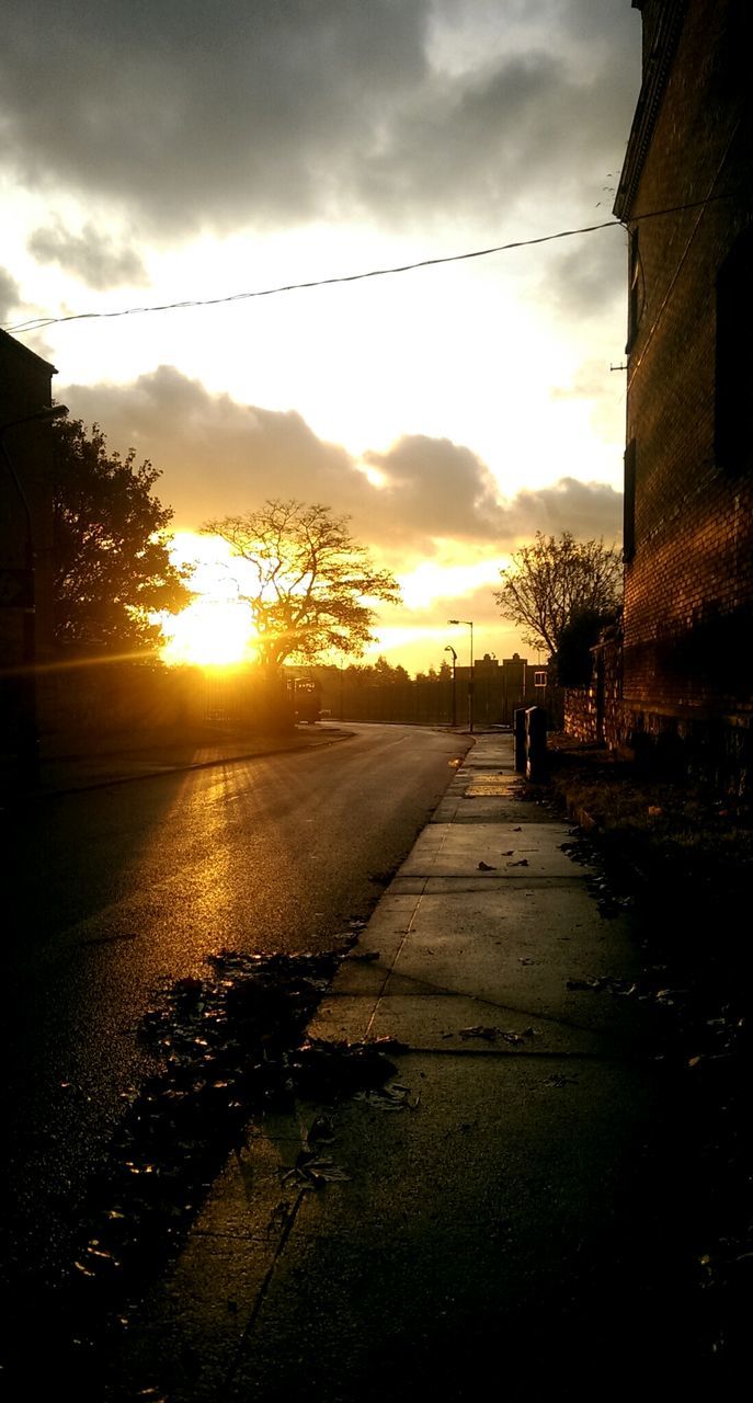 sunset, sky, cloud - sky, the way forward, orange color, building exterior, sun, built structure, architecture, street, sunlight, cloudy, cloud, road, diminishing perspective, silhouette, vanishing point, outdoors, nature, no people