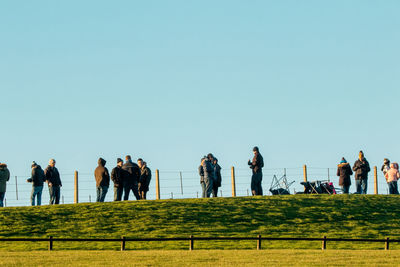 People on field against clear sky