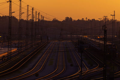 Railroad tracks against sky during sunset