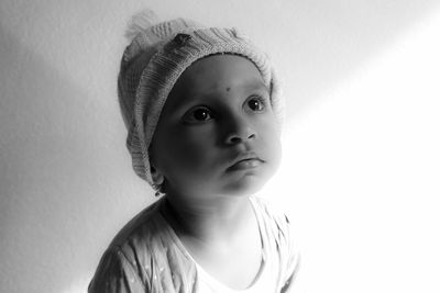 Close-up of girl sitting against wall at home