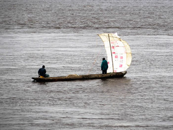 Men sitting on boat in river