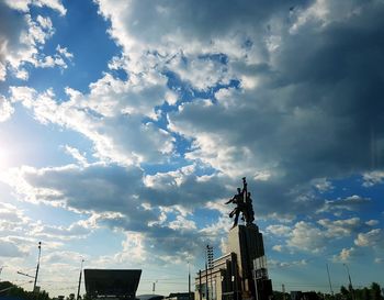Low angle view of statue of building against cloudy sky