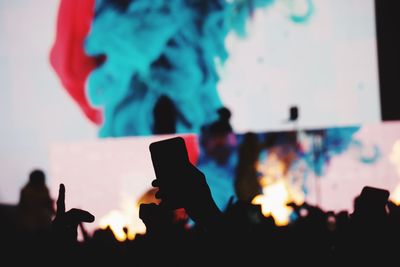 Close-up of silhouette people photographing against sky during sunset