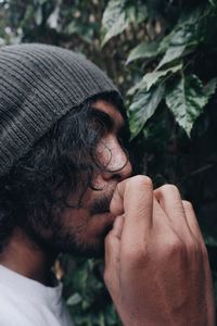 Close-up of man eating against plants