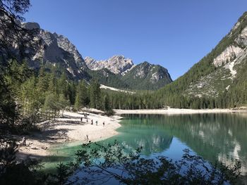 Scenic view of lake and mountains against clear blue sky