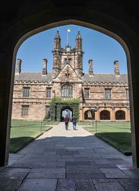 Rear view of people on historical building against sky