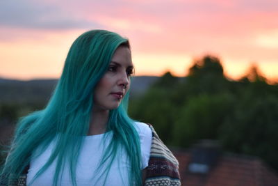 Portrait of beautiful woman standing against sky during sunset