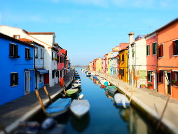 Boats moored in canal amidst buildings in city