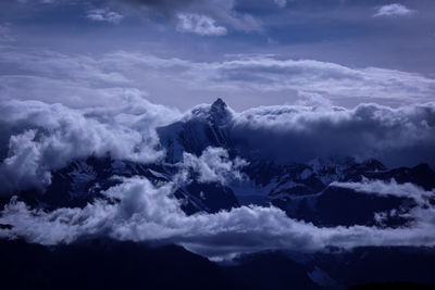 Low angle view of snowcapped mountains against sky