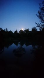 Scenic view of lake against sky at night