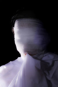 Close-up portrait of young man over black background