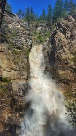 Scenic view of waterfall against sky