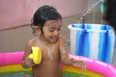 Portrait of a smiling girl holding wet outdoors