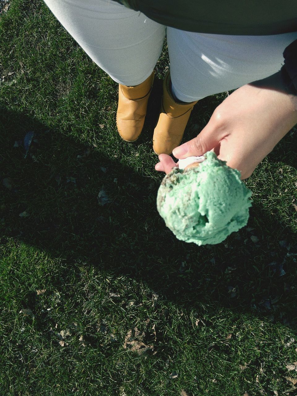 HIGH ANGLE VIEW OF PERSON HOLDING ICE CREAM