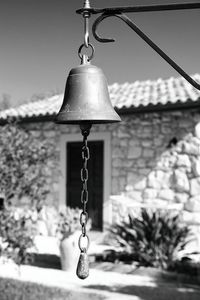 Low angle view of electric lamp hanging on building